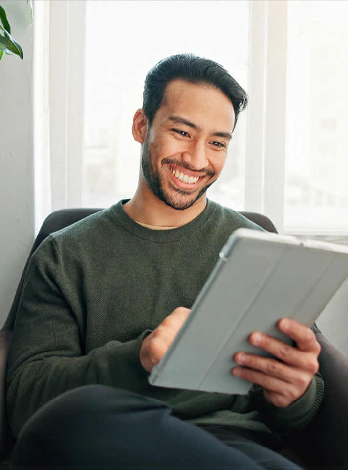 Estudante sorrindo enquanto lê o material em PDF no tablet
